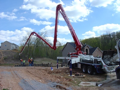 Concrete boom pump extended over a jobsite